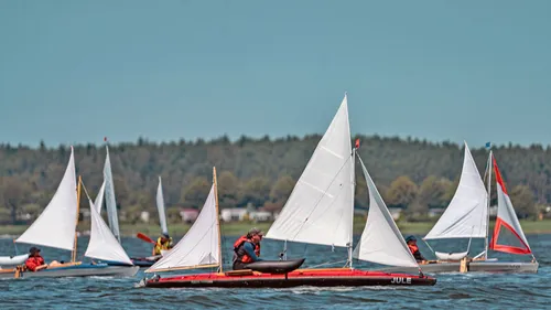 Sailboats racing on a calm lake.