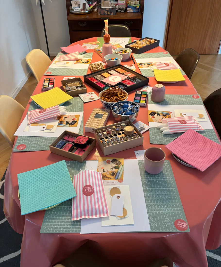 Craft supplies and snacks arranged on dining table.