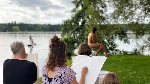 People sketching a model by the lake.