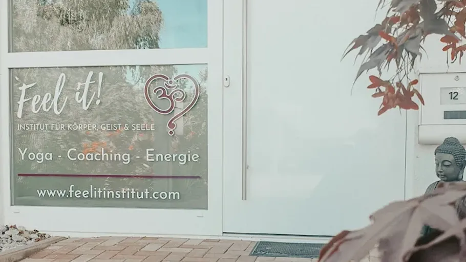 Entrance with yoga institute sign and plants.