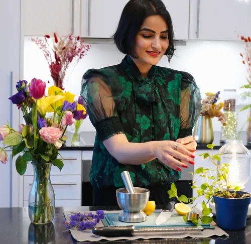 Woman preparing herbs in modern kitchen.