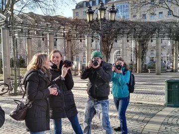 Personen fotografieren sich in einem Stadtpark mit Laternen.