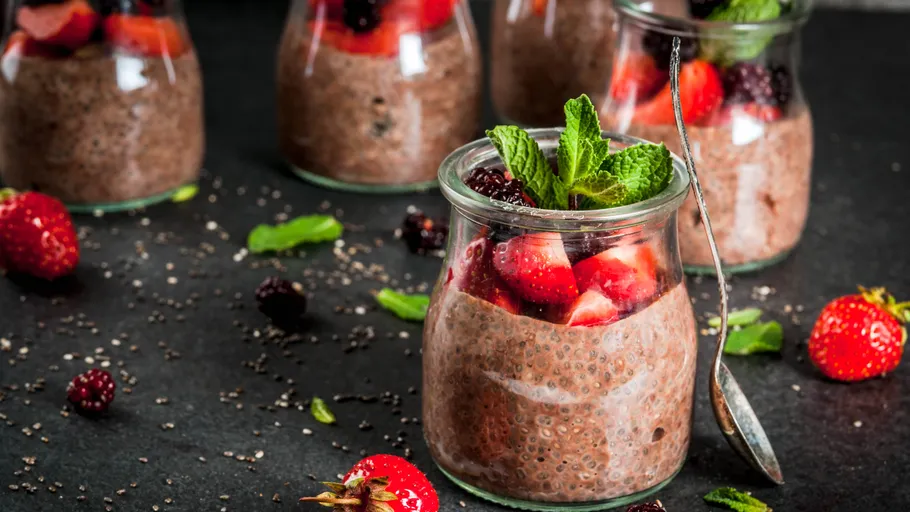 Chia pudding with berries in glass jars.