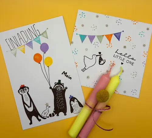 Two illustrated cards and three candles on yellow.