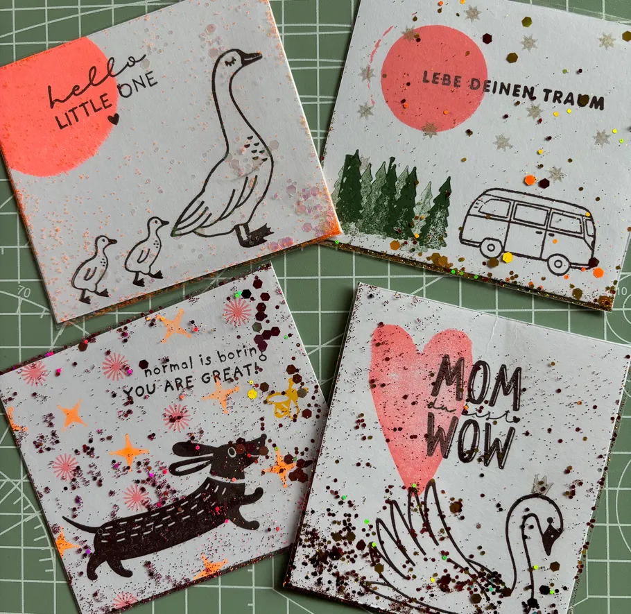 Vier verzierte Karten mit Illustrationen und Text.