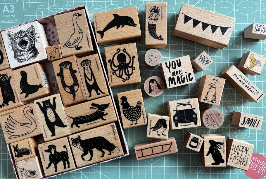 Various wooden stamps on a crafting mat.