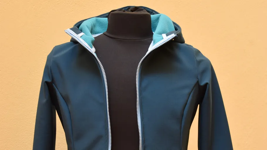 Blue jacket on mannequin against beige background.