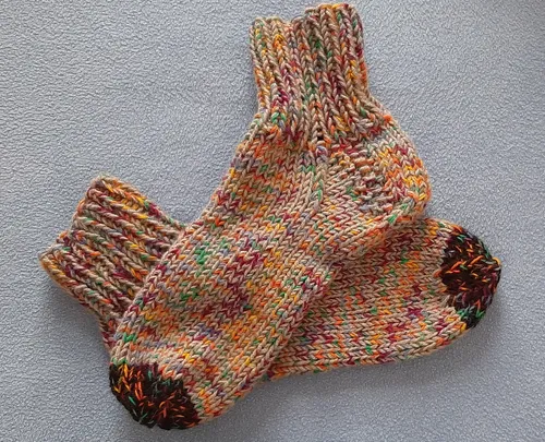 Mehrfarbige gestrickte Socken auf einer Fläche.