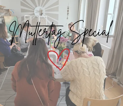 Frauen basteln an einem Tisch drinnen.