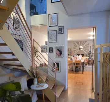 Staircase with art leading to dining room.