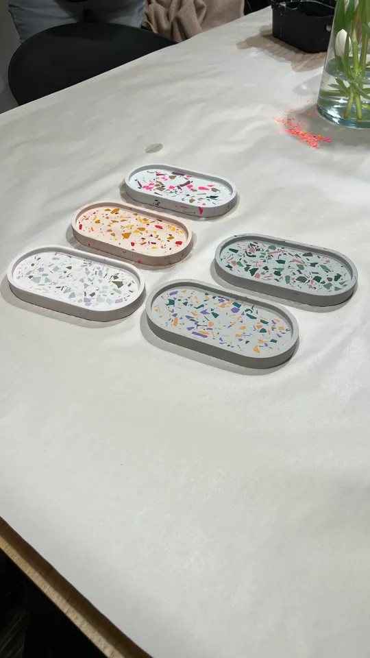 Bunte Tabletts mit Terrazzo-Muster auf Tisch.