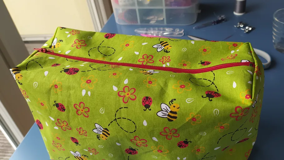 Grüne Stofftasche mit Bienen- und Marienkäfermuster.