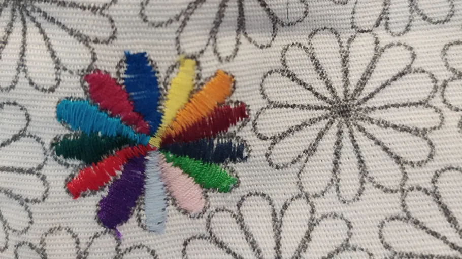 Bunte Stickerei auf geblümtem Stoff.