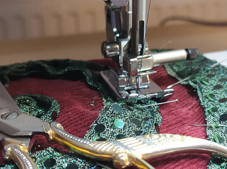Sewing machine stitching green fabric.