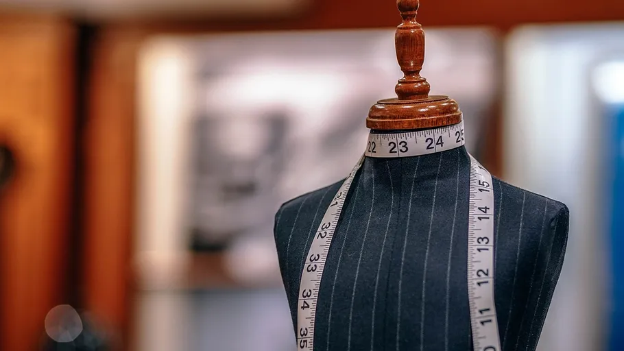 Tailor mannequin with measuring tape around neck.