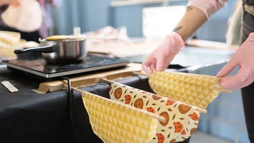 Hand holds fabrics over a cooking surface to dry
