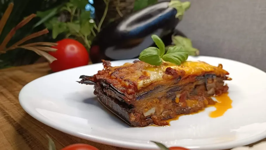 Auberginen-Lasagne-Stück mit Basilikumgarnitur.