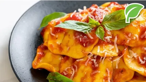 Ravioli with tomato sauce and basil garnish.
