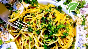 Spaghetti mit Kräutern auf einem weißen Teller.