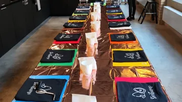 Table set with colorful aprons and cups.