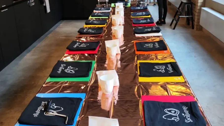 Table set with colorful aprons and cups.