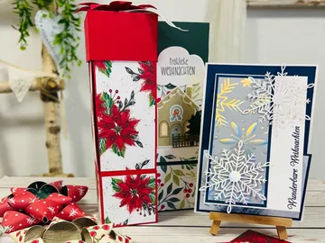 Geschenkschachteln und Weihnachtskarte sind auf einem Tisch.
