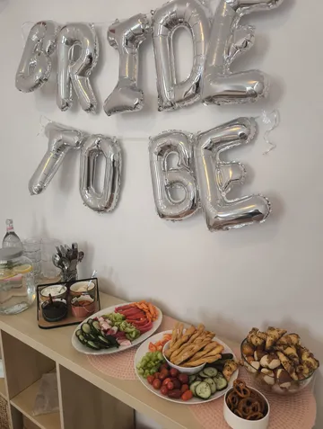 "Bride-to-be"-Schild über dekoriertem Snacktisch.