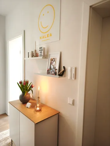 Flur mit Schrank, Vase und Kerze.