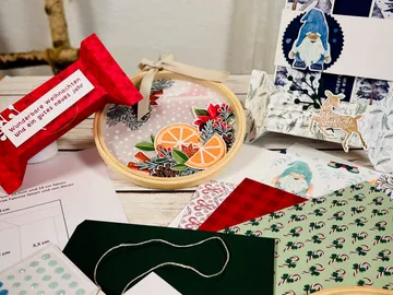 Creative craft materials are strewn across a table.