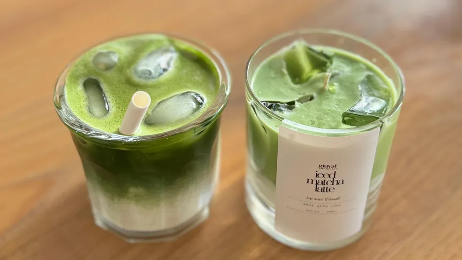 Two iced matcha lattes on wooden table.