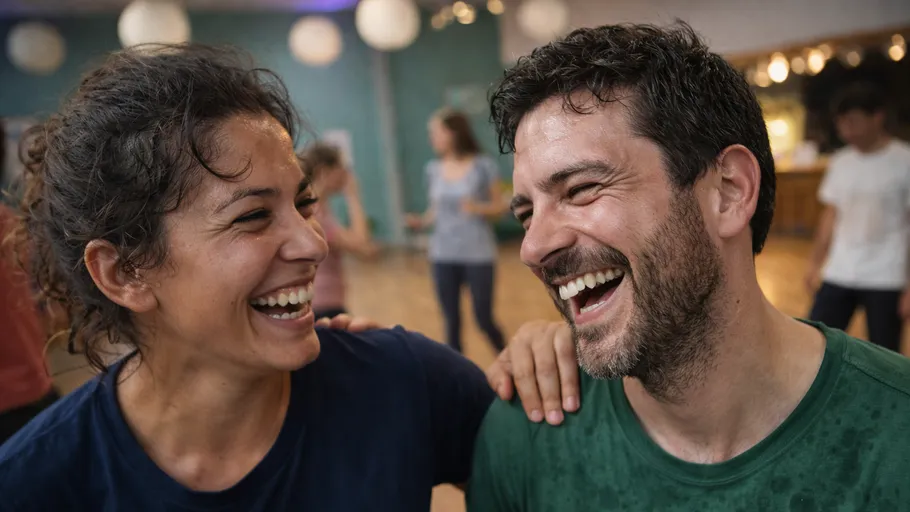 Zwei Personen lachen zusammen in einem Studio.