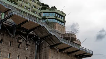 Betongebäude mit Dachbegrünung und Terrassen.