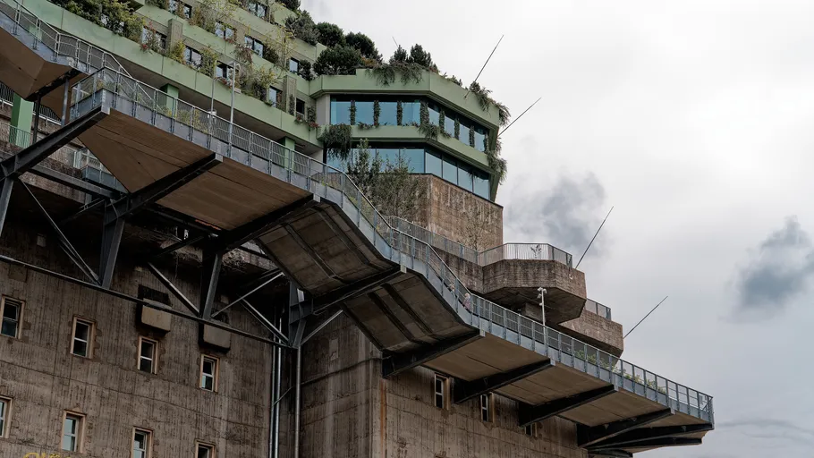 Concrete building with rooftop greenery and terraces.