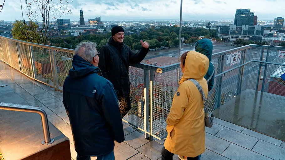 Group of people viewing city from rooftop.