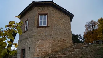 Stone building with steps in rural setting.