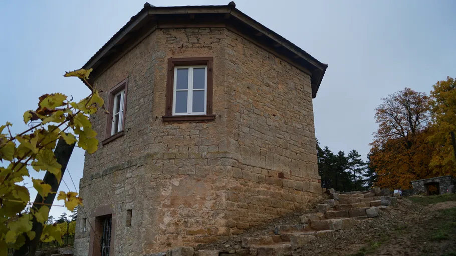 Stone building with steps in rural setting.