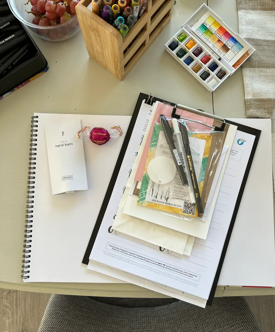 Desk with art supplies and stationery.