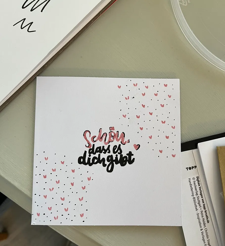 Greeting card with heart decorations on table