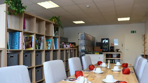 Cozy room with tables, chairs, and bookshelves.
