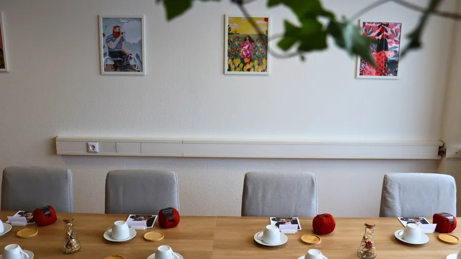 Meeting room with art on walls and tableware.
