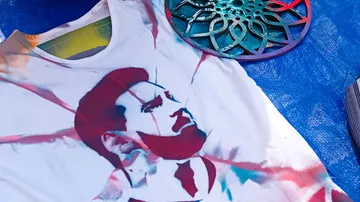 T-shirt with stencil art of a man, blue background.