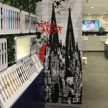 Watches displayed in a store with graffiti mural.