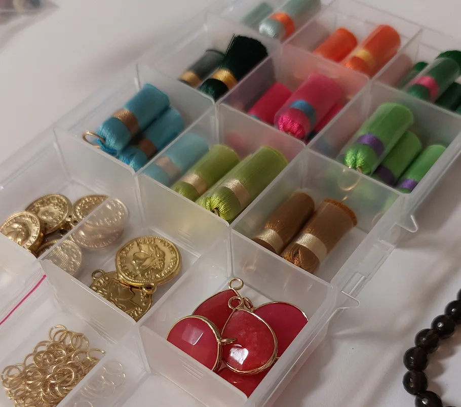 Box with colorful threads and jewelry components.