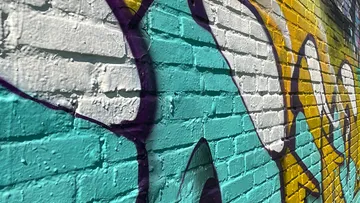 Brick wall with colorful graffiti artwork.