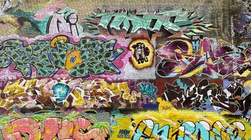 Colorful graffiti covering brick wall.