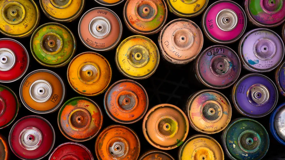 Colorful spray paint cans viewed from above.