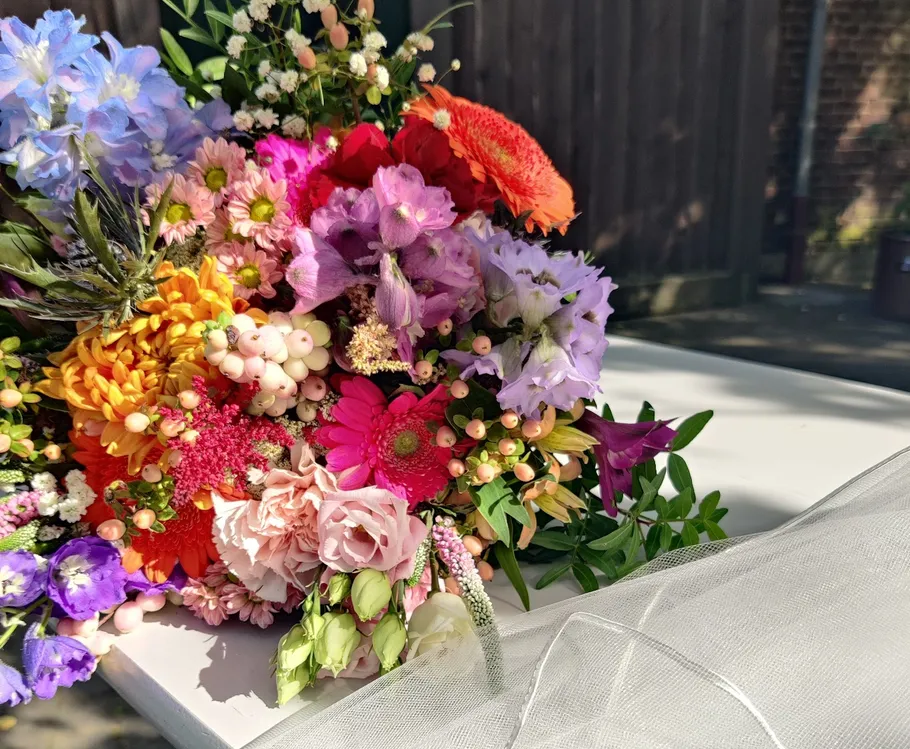 Colorful bouquet on a white table outdoors.