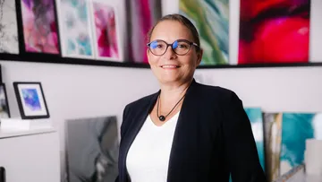 Person lächelt in einer Kunstgalerie.
