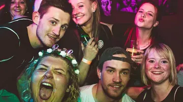 Gruppe von Menschen lächelnd und posierend auf einer Party.