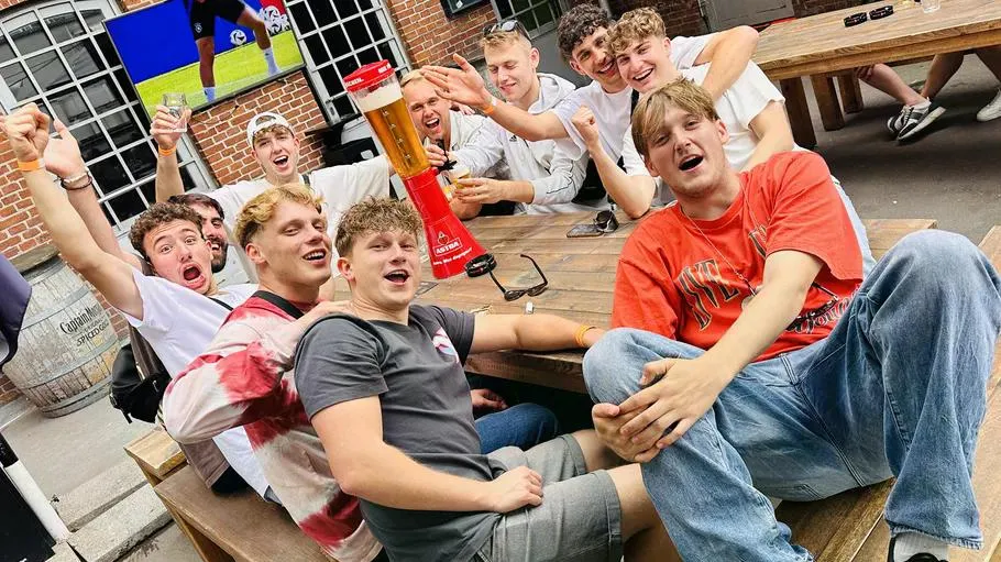 Gruppe Männer feiert an einem Außentisch.